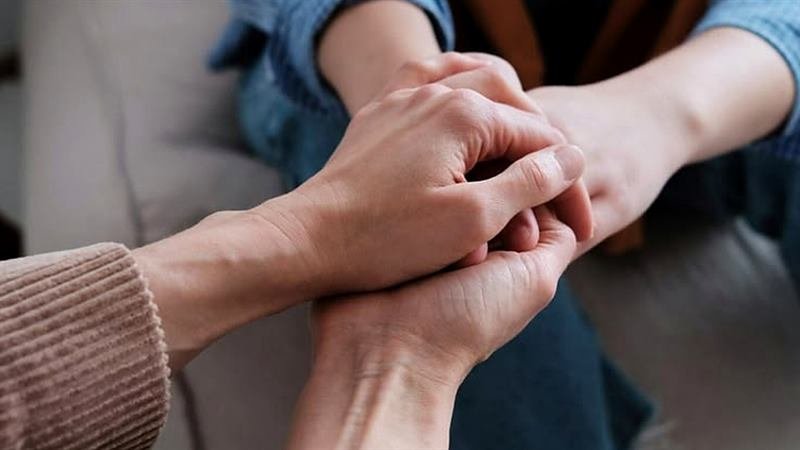 Dos personas tomadas de las manos durante una sesión de terapia de pareja